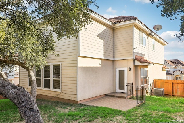 back of house with a yard and central AC