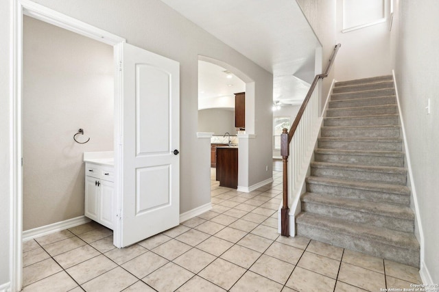 stairway featuring tile patterned floors and ceiling fan