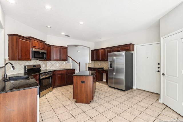 kitchen with backsplash, a center island, sink, and appliances with stainless steel finishes