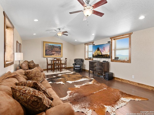 living room with a textured ceiling, dark hardwood / wood-style flooring, and vaulted ceiling