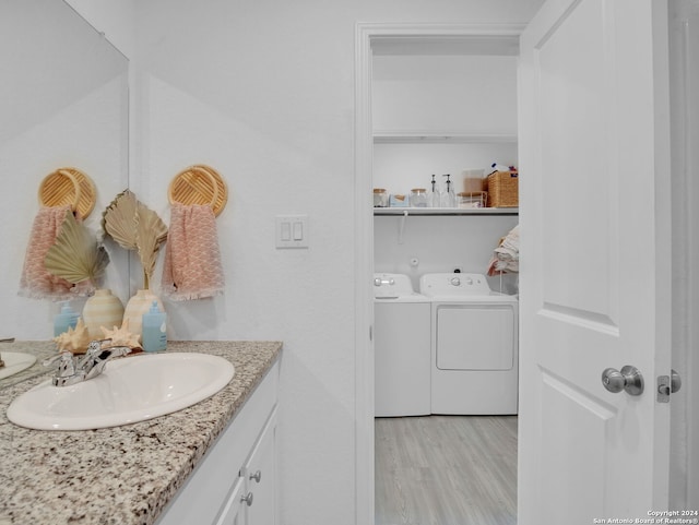 bathroom with washer and dryer, vanity, and hardwood / wood-style flooring