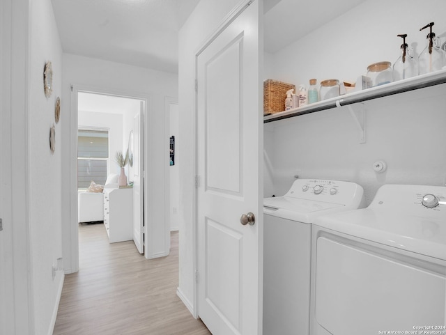 washroom featuring washing machine and clothes dryer and light wood-type flooring