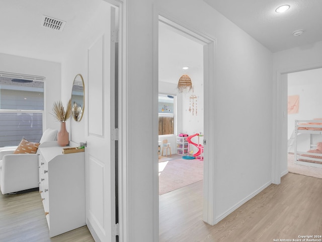 hallway with light hardwood / wood-style floors