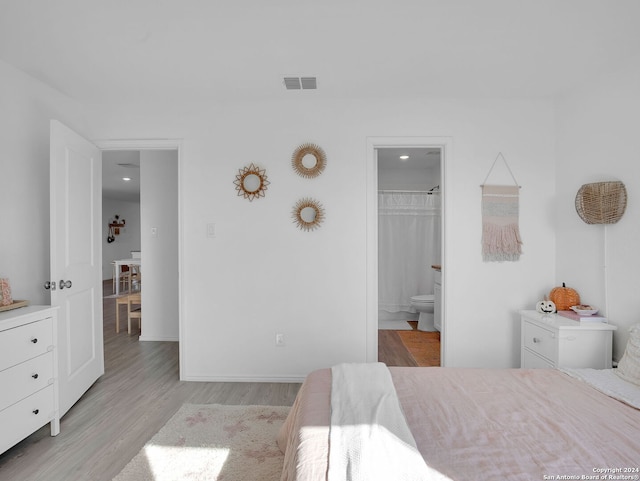 bedroom with a spacious closet, a closet, and light hardwood / wood-style floors