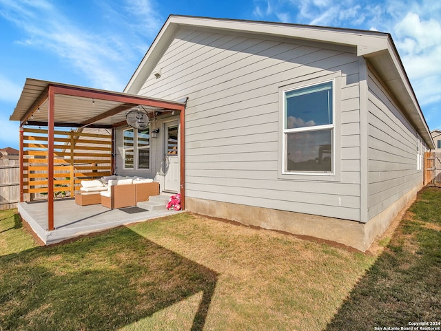 rear view of property featuring a lawn, a patio, and an outdoor hangout area