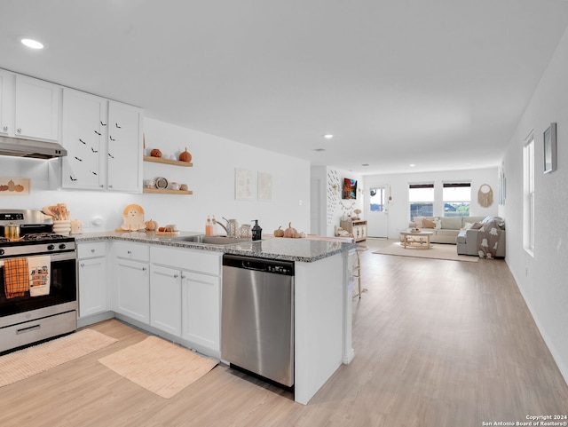 kitchen featuring white cabinets, sink, light stone countertops, light hardwood / wood-style floors, and stainless steel appliances