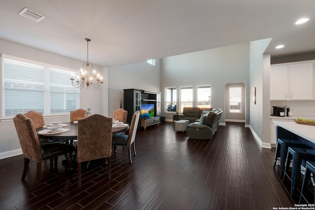 dining space featuring dark wood-type flooring and a chandelier