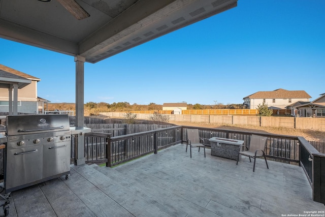 view of patio featuring ceiling fan, area for grilling, and a wooden deck