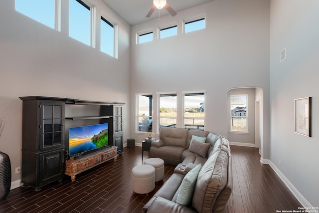 living room with ceiling fan and a high ceiling