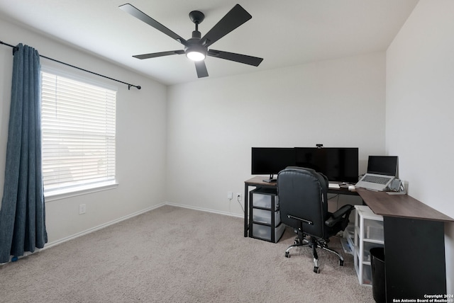 office area featuring a healthy amount of sunlight, ceiling fan, and light colored carpet