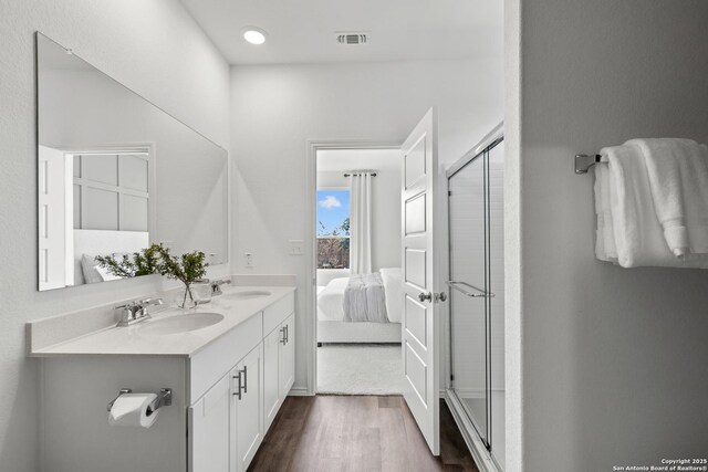 bathroom featuring vanity, wood-type flooring, and walk in shower