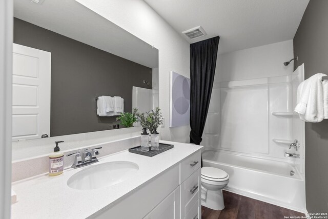 full bathroom featuring hardwood / wood-style floors, vanity, toilet, and shower / tub combo with curtain