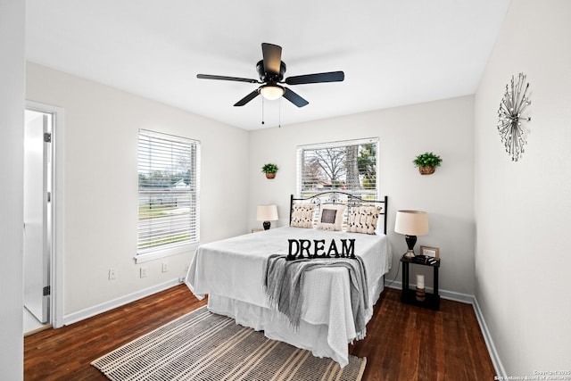 bedroom featuring multiple windows, dark hardwood / wood-style floors, and ceiling fan