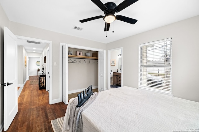 bedroom with ensuite bathroom, a closet, dark wood-type flooring, and ceiling fan