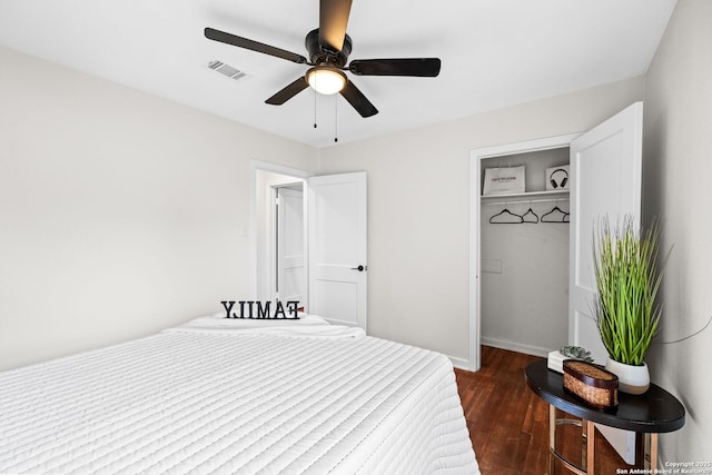 bedroom with ceiling fan, dark wood-type flooring, and a closet