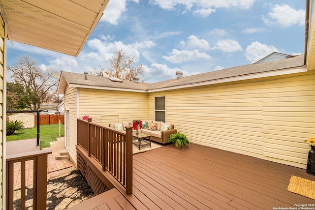 wooden deck with outdoor lounge area and a shed