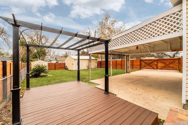 wooden deck with a pergola, a patio area, a lawn, and a storage unit