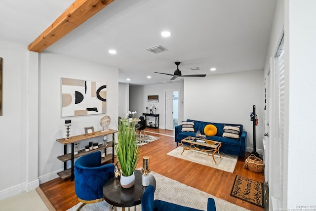 living room featuring ceiling fan, beamed ceiling, and hardwood / wood-style flooring