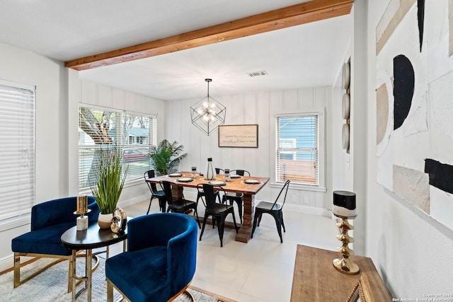 dining room with beam ceiling and an inviting chandelier