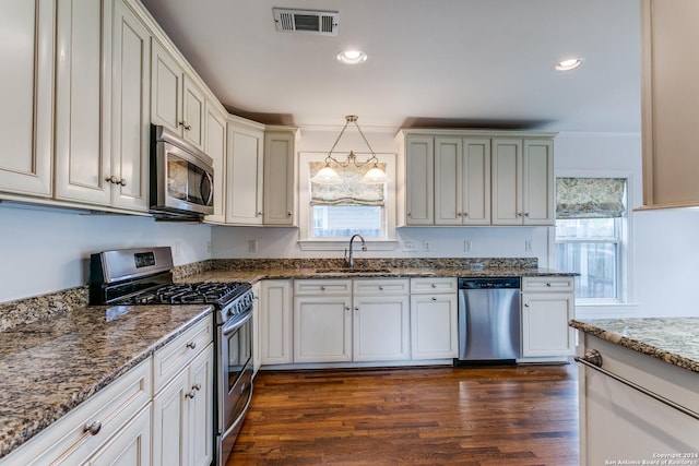 kitchen with dark hardwood / wood-style flooring, sink, stainless steel appliances, and hanging light fixtures