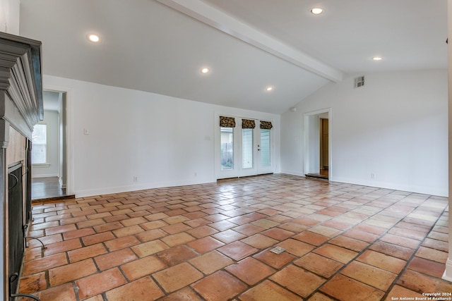 unfurnished living room featuring french doors and vaulted ceiling with beams