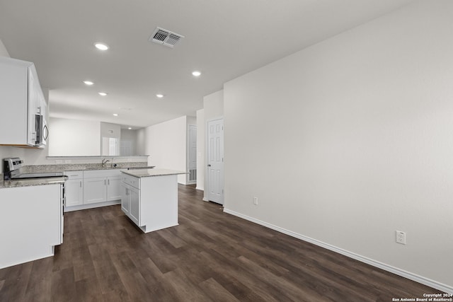 kitchen featuring stove, white cabinets, sink, dark hardwood / wood-style floors, and a kitchen island