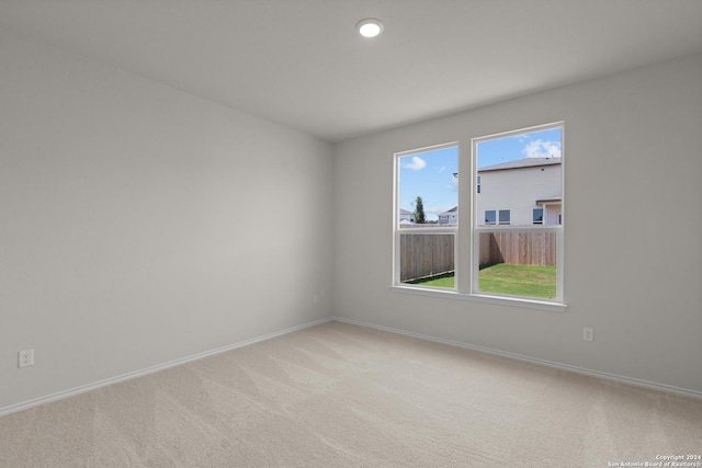 carpeted spare room featuring plenty of natural light