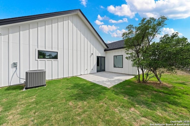 back of property featuring cooling unit, a patio area, and a yard