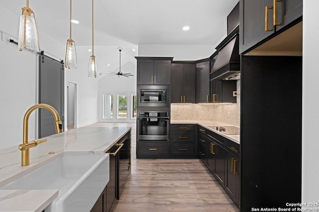 kitchen with stainless steel microwave, oven, sink, ceiling fan, and light stone countertops