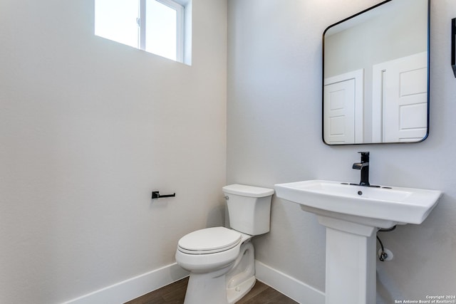 bathroom with hardwood / wood-style flooring and toilet