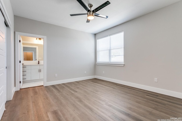 unfurnished bedroom featuring ensuite bathroom, light hardwood / wood-style flooring, and ceiling fan