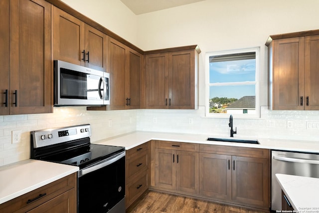 kitchen featuring decorative backsplash, sink, appliances with stainless steel finishes, and light hardwood / wood-style flooring