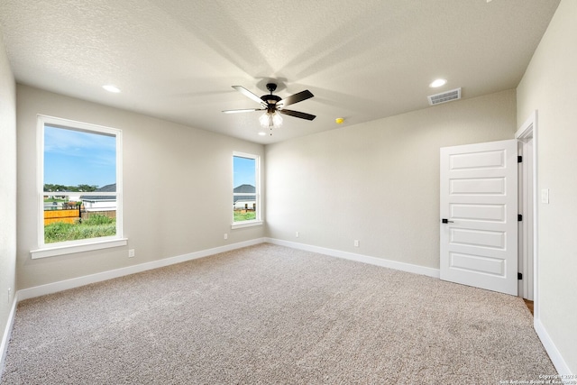 unfurnished room featuring carpet flooring, ceiling fan, and a textured ceiling