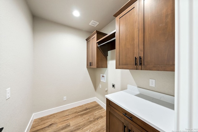 laundry area featuring light hardwood / wood-style floors, cabinets, washer hookup, and hookup for an electric dryer