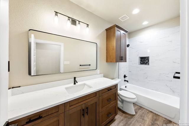 full bathroom featuring wood-type flooring, vanity, toilet, and tiled shower / bath