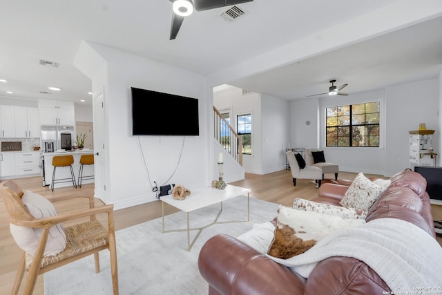 living room featuring light hardwood / wood-style floors and ceiling fan