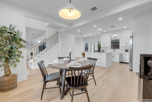 dining room with light wood-type flooring and sink