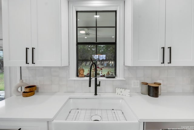 interior details featuring white cabinets, backsplash, dishwasher, and sink