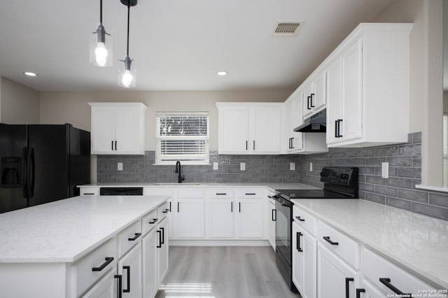 kitchen with backsplash, black appliances, white cabinets, sink, and hanging light fixtures