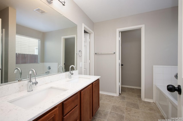 bathroom with vanity and a tub