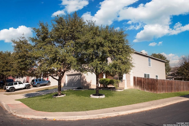 obstructed view of property featuring a garage and a front yard