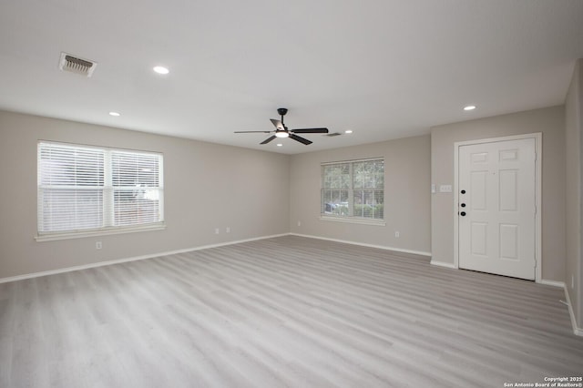 unfurnished living room with light hardwood / wood-style floors, ceiling fan, and a healthy amount of sunlight