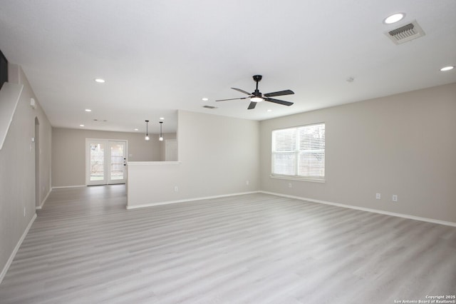 empty room with french doors, light wood-type flooring, and ceiling fan