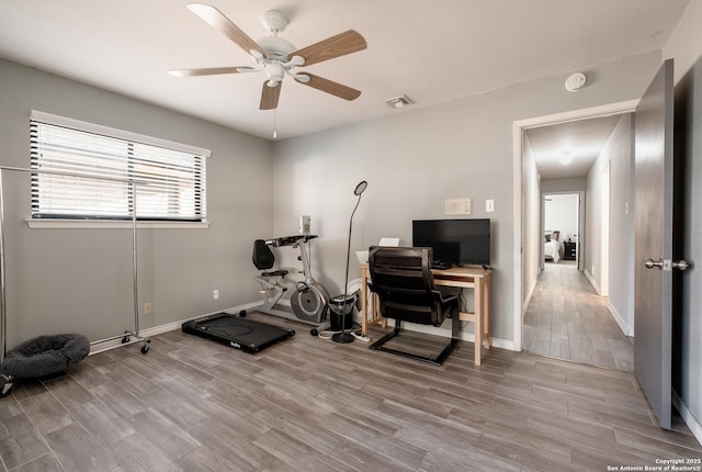 workout area featuring light hardwood / wood-style floors and ceiling fan