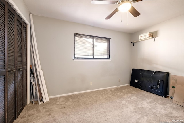 unfurnished bedroom with ceiling fan, a closet, and light carpet