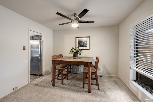 dining room with light colored carpet and ceiling fan