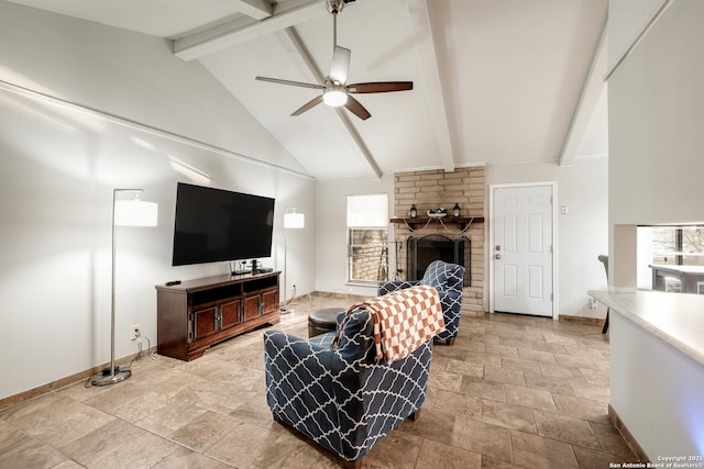 living room with beamed ceiling, ceiling fan, a stone fireplace, and high vaulted ceiling