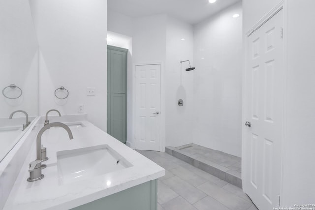 bathroom with a tile shower and vanity