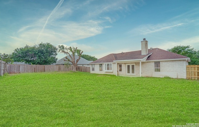 rear view of property with a yard