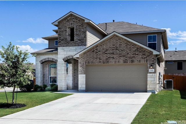 front facade with a front yard, central AC unit, and a garage